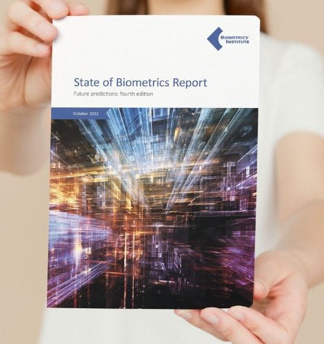 Woman holding a copy of the Biometrics Institute State of Biometrics Report