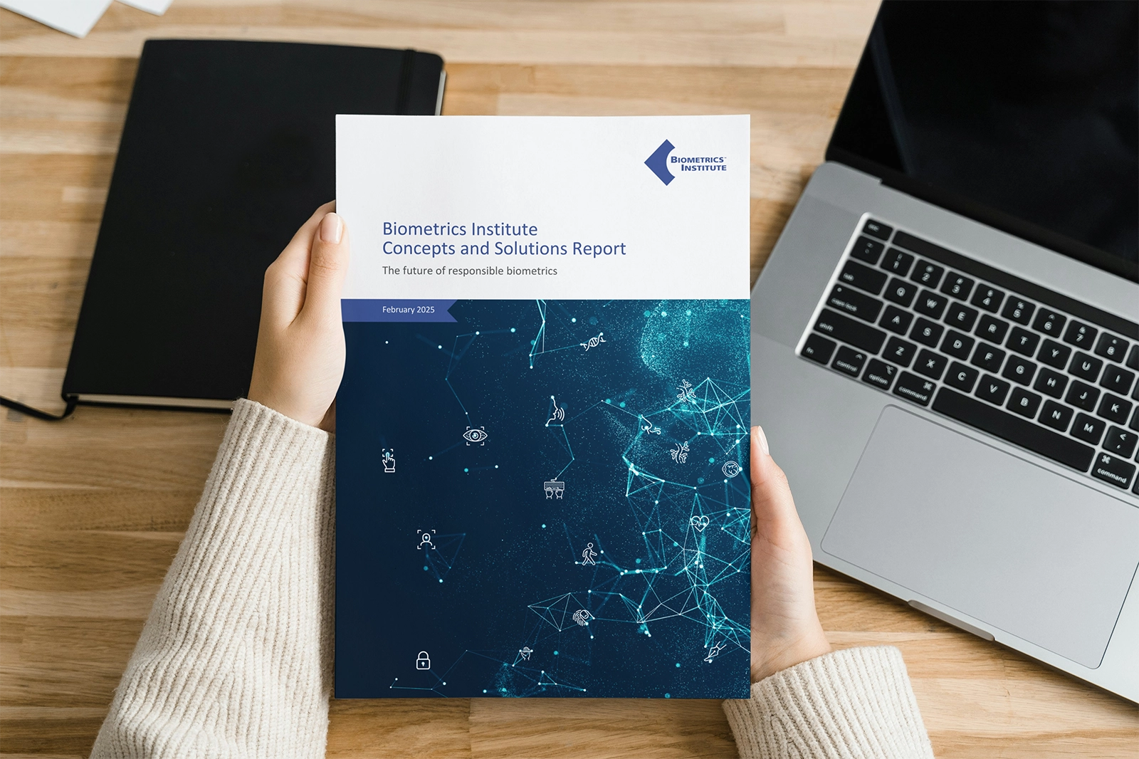 Woman holding a Biometrics Concepts and Solutions report featuring case studies from Biometrics Institute members on the future of responsible biometrics